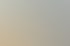 Sonniger Balkon mit runden Tischen, einer Farnpflanze im Topf, einem Sessel und Blick auf benachbarte Hausdächer.