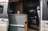 Innenansicht eines ausgebauten Mercedes Sprinter mit modularer Küche, Campingtisch und Techniksystem von Reisewagenworks – individueller Camper Ausbau mit Fokus auf Funktion und Stil