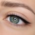 Nahaufnahme eines weiblichen Auges mit blauer Iris, schwarzem Eyeliner und langen Wimpern.
