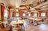 Ein gemütliches Restaurant mit Holzvertäfelung, Tischen, Stühlen und Bänken, rustikal dekoriert.
