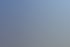 Zwei moderne Bürogebäude mit großen Fenstern und beleuchteten Innenräumen bei Dämmerung, der Himmel ist dunkelblau.