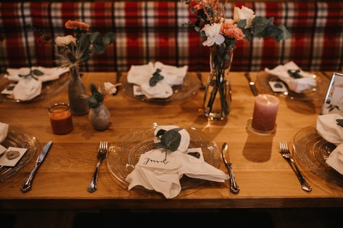 Festlich gedeckter Holztisch mit Kerze und Blumen