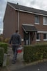 HSR-Monteur mit Werkzeugkoffer auf dem Weg zu einem Wohnhaus