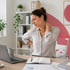A pained woman at her desk seeks pinched nerve treatment for her back.