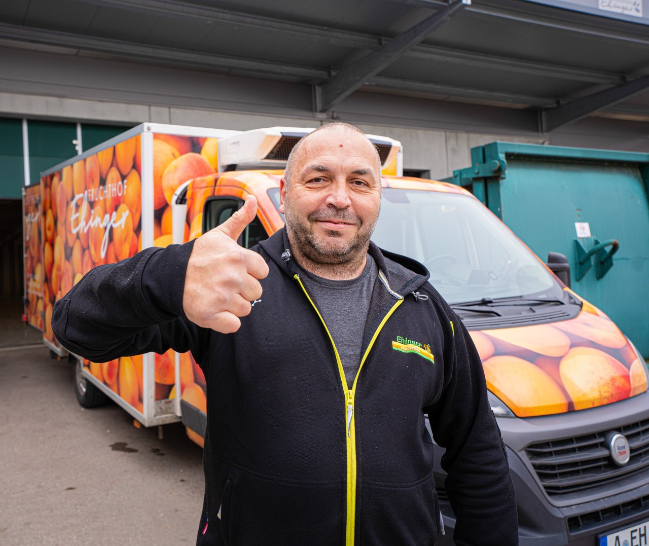 Auslieferungsfahrer am LKW eines Lebensmittelgroßhandels