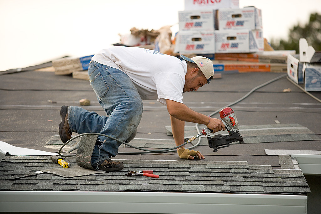 Roofer working across a low-slope commercial roof deck