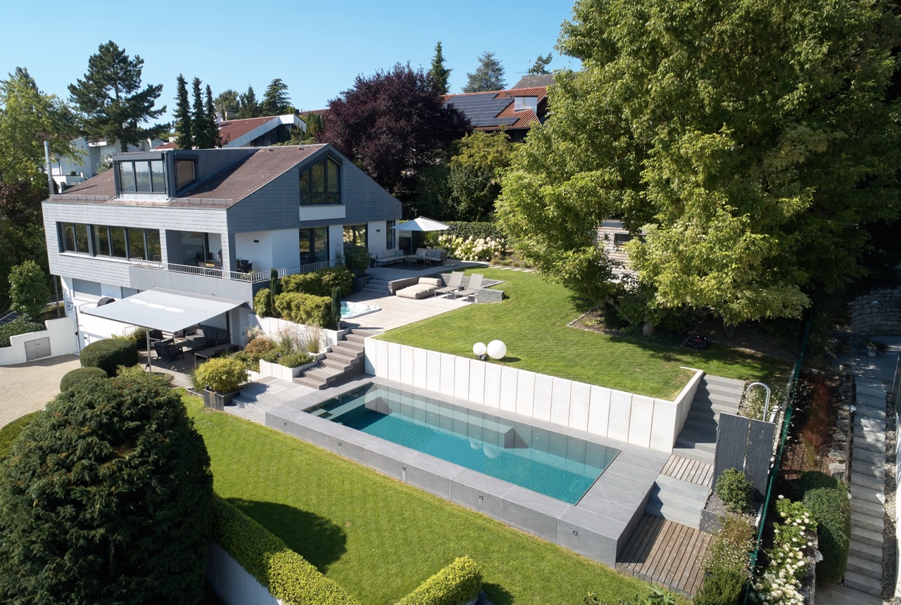 Geradlinige Poolanlage mit Naturstein und integrierter Sitzbank – Ansicht 2