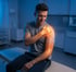 Man with shoulder pain sitting in a doctor's office seeking treatment.