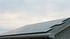 Photovoltaikmodule auf einem Satteldach unter bedecktem Himmel