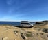 Ausgebauter Campervan auf Küstenstraße mit Weitblick über das Meer – autarkes Reisen im Reisewagen