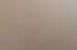 Eine lächelnde Frau mit lockigem braunem Haar lehnt an einer hellbraunen Wand.