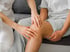 A close-up of a doctor examining a patient's knee.