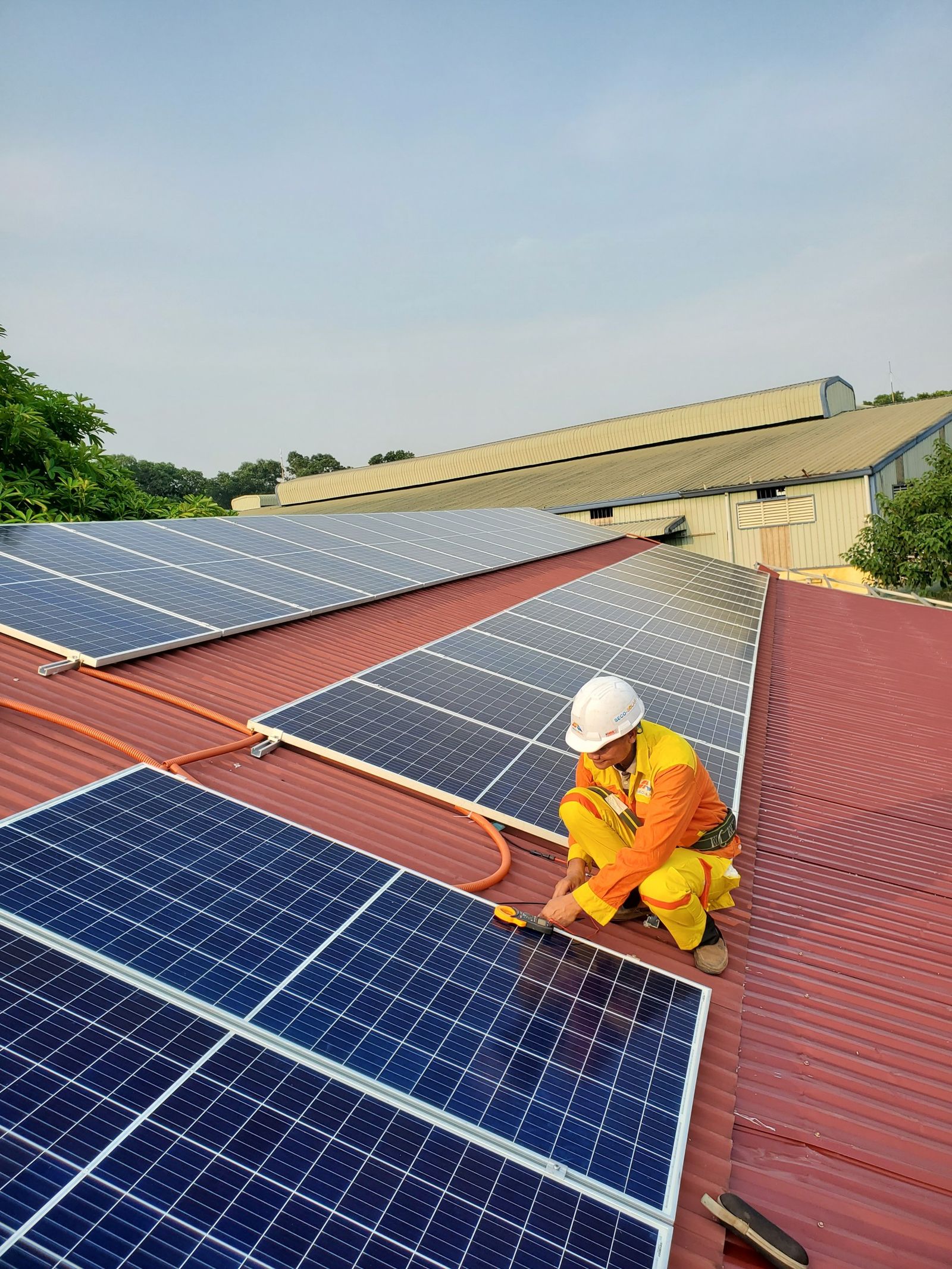 Techniker richtet ein Photovoltaikmodul auf dem Dach aus