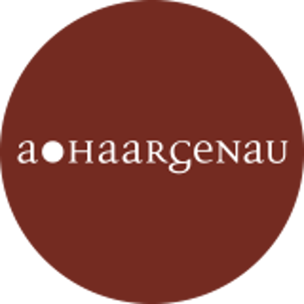 Roter Kreis mit weißem Text "a HaarGENAU".