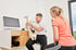 Physiotherapeut LANDphysio Lauchdorf erklärt Patientin Rückenschmerzen anhand Wirbelsäulenmodell im Ostallgäu
