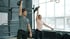 Mann und Frau heben Kettlebells über Kopf beim CrossFit-Training.