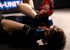 Ein MMA-Kämpfer liegt auf dem Rücken, während ein anderer Kämpfer seine Faust auf dessen Kopf drückt.