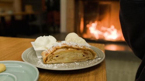 Apfelstrudel mit Vanilleeis vor dem Kaminfeuer im aatal.HAUS