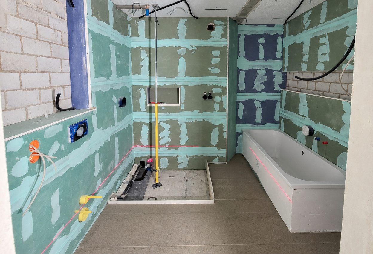 Installationswand im Bad mit WC-Vorwand, Duschnische und Wannenverkleidung im Rohbau