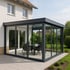 Moderner Anbau eines Wintergartens mit Flachdach an ein Wohnhaus in Leutkirch, mit klarer Linienführung und großzügiger Glasfront.
