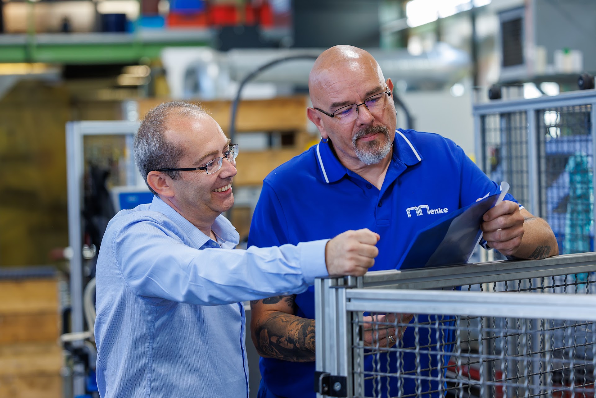 Zwei Mitarbeiter der Menke GmbH stimmen sich an einer Fertigungsanlage in Neuenrade ab