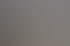 Modernes Konferenzzimmer mit Glastüren, vier orangefarbenen Stühlen, einem runden Tisch und einem Whiteboard.