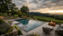 Infinity-Pool mit Terrasse, Feuerstelle und Weinbergen bei Sonnenuntergang.