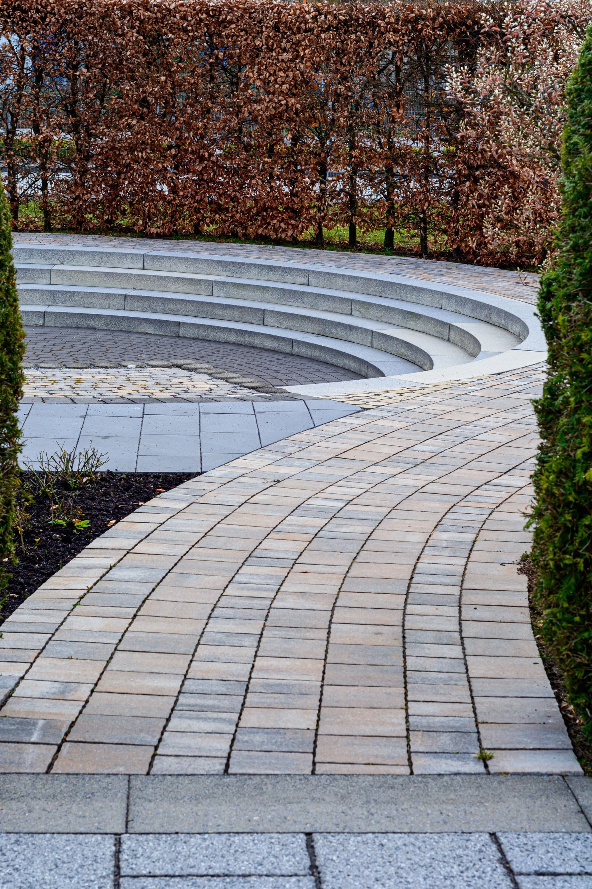 Moderner Garten mit geschwungenem Klinkerweg und Sitzsenke