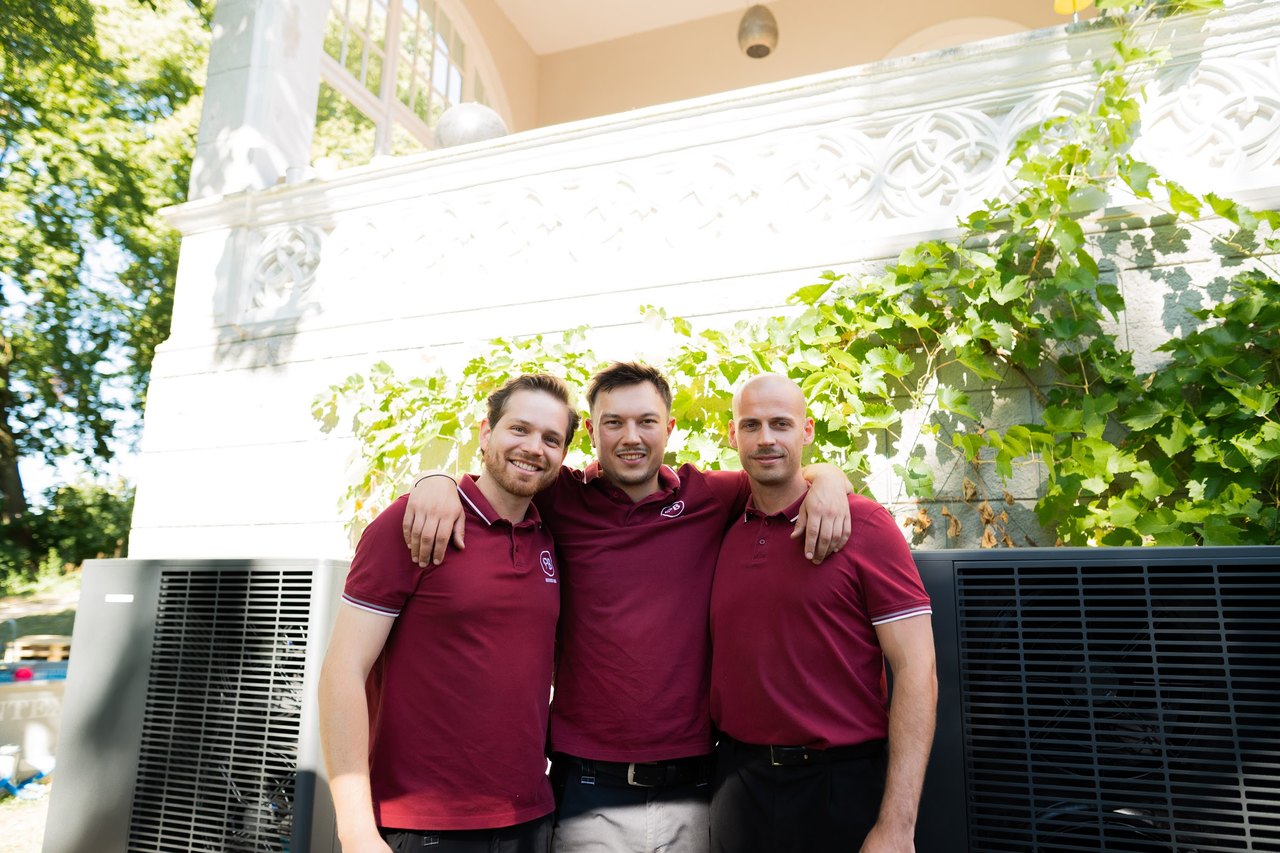Marvin Prätz, Niklas Bulk und Adrian Meyer von PB HeizWerk vor einer Wärmepumpe
