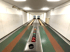 Zwei leere Kegelbahnen mit roten und grünen Bowlingkugeln auf dem Ballrücklauf.