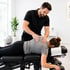Chiropractor treats nerve pain by adjusting a woman's upper back.