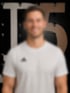 Lächelnde Mann mit langen blonden Haaren im weißen T-Shirt vor einem Hintergrund im Pier5