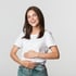 Smiling young woman in white t-shirt and jeans, holding stomach, representing gut issues.