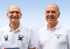 Drei lächelnde Männer in weißen Poloshirts stehen vor einem dunklen Fahrzeug mit dem Firmennamen „Kurth Rathberger“.
