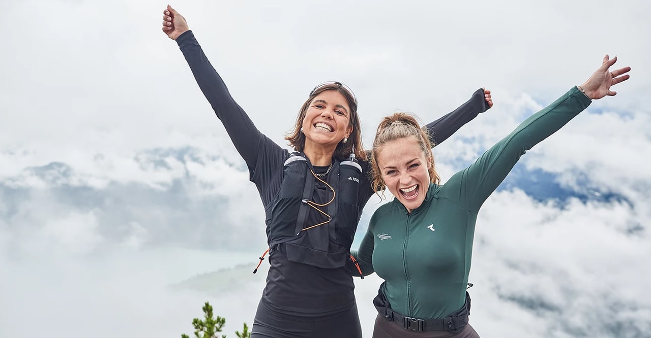 Zwei Frauen jubeln auf einem Berggipfel