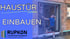 Zwei Arbeiter installieren eine Rupkon-Haustür in einem Rohbau. Text: "HAUSTÜR EINBAUEN", "RUPKON Leichtmetall-Haustüren".