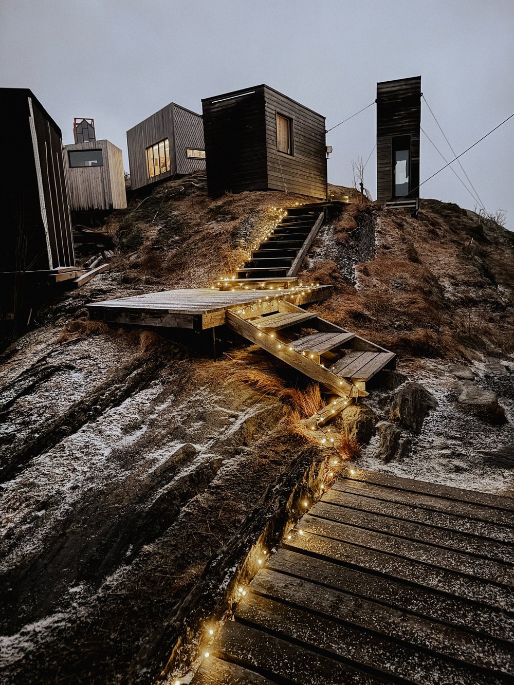 Beleuchtete Treppe zu Hütten auf dem Fels