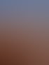 Sonnenuntergang über dem Meer mit orangem Himmel, Strand, Sanddünen und zwei Personen.