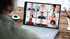 Person nimmt an einer Videokonferenz auf einem Laptop mit neun Teilnehmern in einer Gitteransicht teil.
