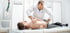 Physical therapist performing chiropractic care on a man's back.