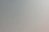 Eine Lehrerin beugt sich über ein kleines Mädchen, das am Tisch zeichnet, ein Junge sitzt links.