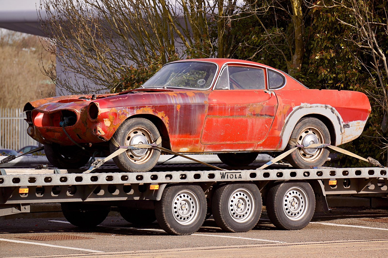 how to tow a lowered car: a low coupe secured on a flatbed tow truck deck in Orlando, FL