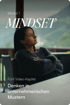 Modul 1 Mindset: Frau sitzt, Arme verschränkt, blickt nachdenklich. Text: Fünf Video-Kapitel Denken in unternehmerischen Mustern.