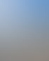 Ein vertikaler Lastenaufzug mit einer Saugheber-Vorrichtung unter blauem Himmel mit Häusern im Hintergrund.