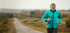 Smiling elderly man jogging on a rural road, staying active thanks to A2M injections.