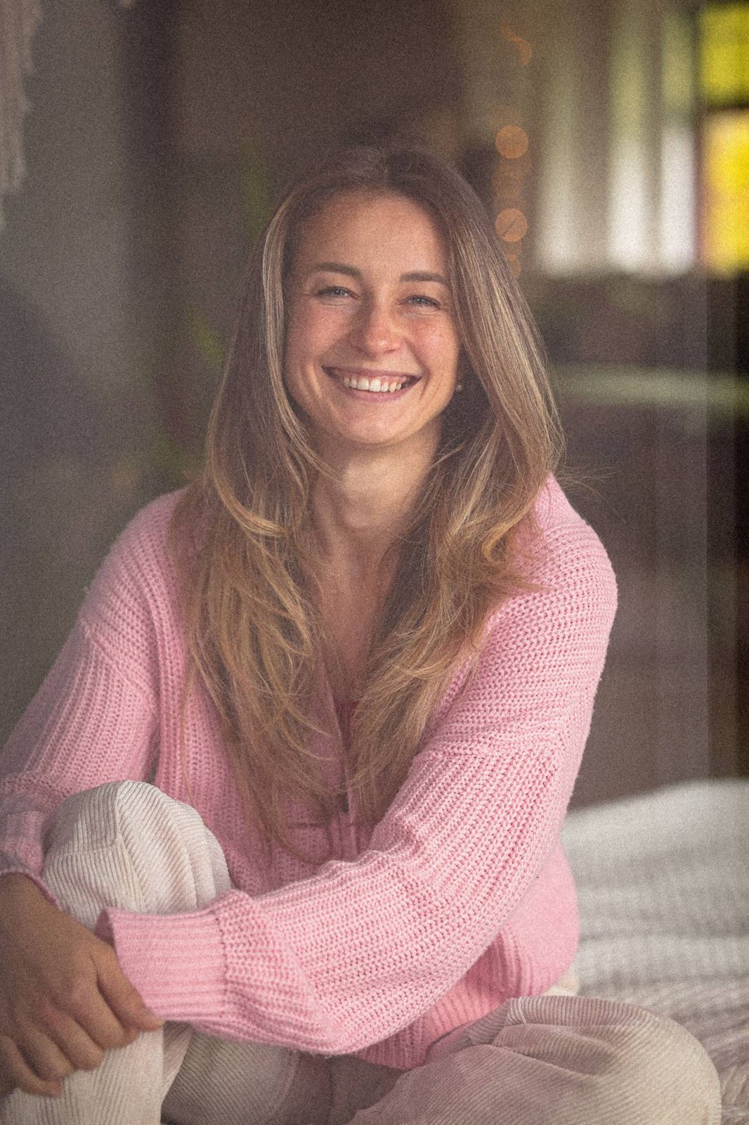 Tatjana Schäfer lächelt im rosa Strickpullover, warmes Licht