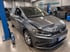 Ein grauer VW Golf mit Frontschaden an der Motorhaube steht in einer Werkstatt von UnfallKompass neben einer Hebebühne.