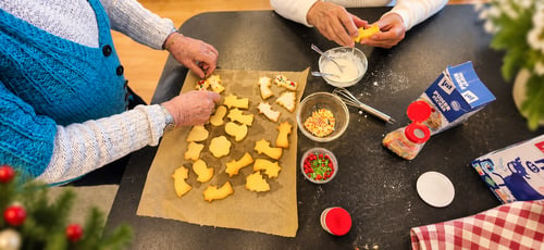 Gemeinsam werden Plätzchen mit Zuckerguss und bunten Streuseln verziert.