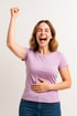 Frau hält ihren Bauch, hält die Faust in die Luft und lacht vor Freude nachdem ihr mit ihr nach der Schwangerschaft von Mommys Belly Repair geholfen wurde.