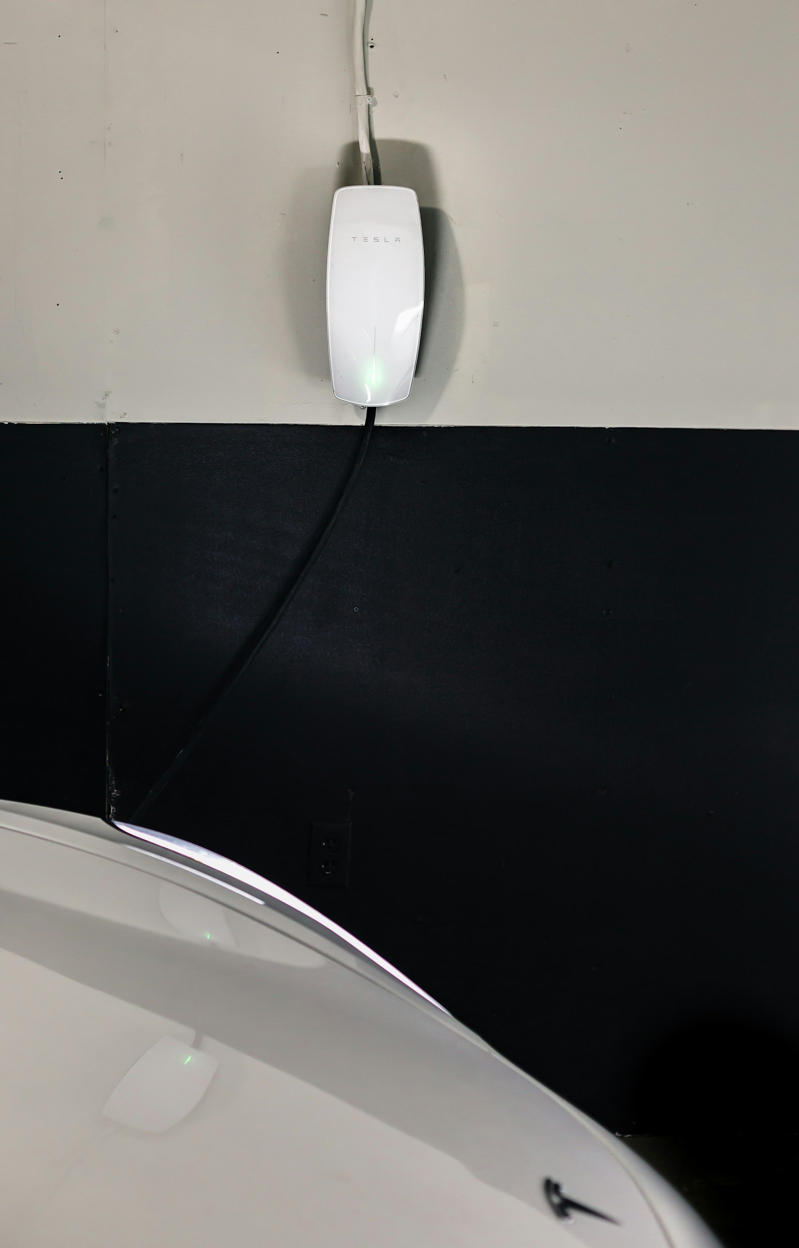 Wall-mounted Level 2 EV charger connected to an electric vehicle in a garage